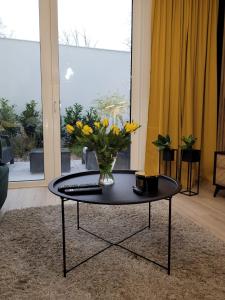 a vase of flowers on a table in a living room at apartament przy plaży w redłowie in Gdynia