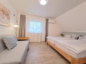 1 Schlafzimmer mit 2 Betten, einem Sofa und einem Fenster in der Unterkunft Hortensie Speyer in Speyer