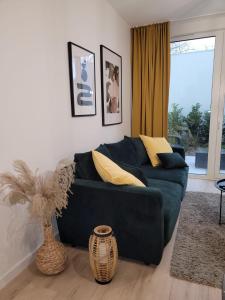 a living room with a blue couch with yellow pillows at apartament przy plaży w redłowie in Gdynia
