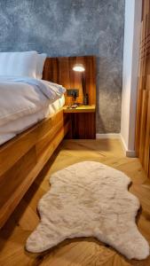 ヤホリナにあるApartman 23 - Aparthotel Poljice Jahorinaのベッドルーム1室(ベッド1台、白いラグ付)