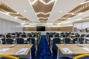 une salle de conférence avec des tables et des chaises ainsi qu'un podium dans l'établissement Premium Inn Mombasa City, à Mombasa