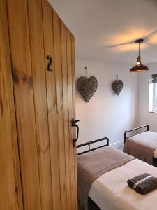 un dormitorio con 2 camas y una puerta con corazones en la pared en The Willow (Alton Towers, Animals, Peak District), en Denstone