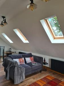 a living room with a blue couch and windows at The Willow (Alton Towers, Animals, Peak District) in Denstone