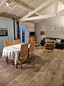 ein Wohnzimmer mit einem Tisch, Stühlen und einem Sofa in der Unterkunft Duinenhuis Zeepolder 27 in De Haan
