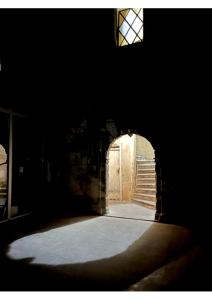 un couloir sombre avec une porte et une fenêtre dans l'établissement Jacques III d'aragon, à Montpellier