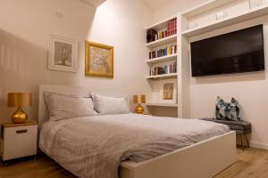 a bedroom with a large bed and a flat screen tv at Casetta al centro in Trento