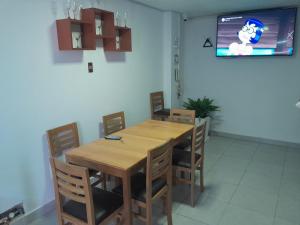 a dining room with a wooden table and chairs at Hospedaje Kaihalulu in Punta Hermosa +18 photos