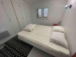 a bedroom with a bed with white sheets and a window at Charmante maison en plein cœur de Collioure in Collioure