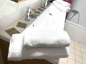 a bathroom with white towels on a sink at Charmante maison en plein cœur de Collioure in Collioure