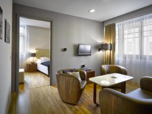 pokój hotelowy z łóżkiem, stołem i krzesłami w obiekcie The ICON Hotel & Lounge w Pradze