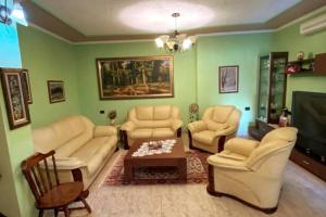 een woonkamer met witte meubels en groene muren bij Vila Lumja in Tirana