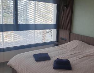 1 dormitorio con 1 cama con 2 toallas azules en Deluxe 1 Bed Apt Ayios Dometios, en Ayios Dhometios