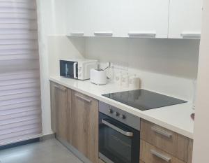 eine Küche mit einer Theke mit einer Mikrowelle und einer Spüle in der Unterkunft Deluxe 1 Bed Apt Ayios Dometios in Ayios Dhometios