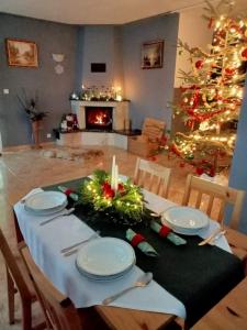 a dining room table with a christmas tree in the background at Agroturystyka u Rysia in Kamienna