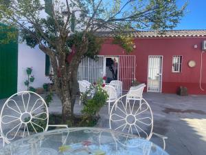 tavolo e sedie di fronte a un edificio rosso di Casa Muriana ad Alanís