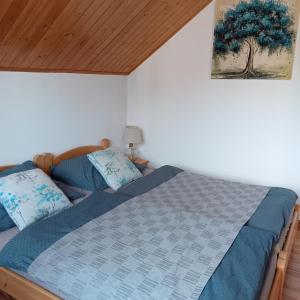 a bedroom with a bed with a blue comforter at Agroturystyka u Rysia in Kamienna