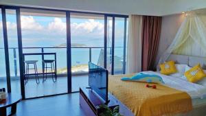 a bedroom with a bed and a view of the ocean at 惠州惠东巽寮湾金铭海景公寓 in Xincun