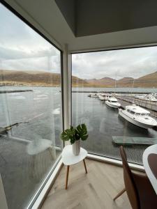 a room with a large window with boats in the water at Brand New Waterfront-Apartment in Hvalvík
