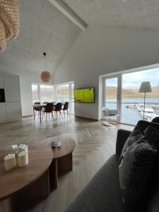 a living room with a couch and a table at Brand New Waterfront-Apartment in Hvalvík