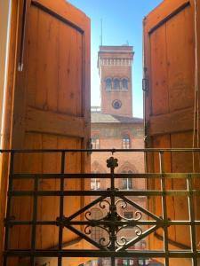 ボローニャにあるAppartamento "San Petronio"" Residenze del Podestà - Centro Bologna & Stazioneの開いた窓から時計塔の景色を望む
