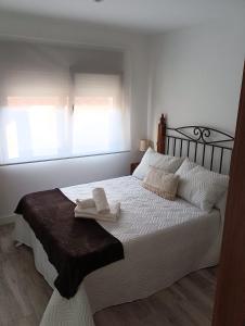 a bedroom with a white bed with two towels on it at CASA ASGAYA in Cudillero