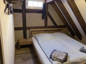 ein Schlafzimmer mit einem Bett im Dachgeschoss mit einem Fenster in der Unterkunft Küferhof Ferienhaus St Martin mit Sauna in Sankt Martin