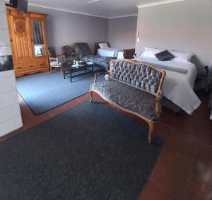 une chambre d'hôtel avec un lit et deux chaises dans l'établissement Beit-El BnB, à Polokwane