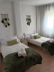 1 dormitorio con 2 camas y toallas. en Apartamento El Pilar, en Güéjar-Sierra
