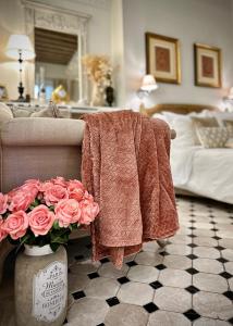 un salon avec un canapé et des roses roses dans l'établissement Les Anges Deluxe Avignon, à Avignon