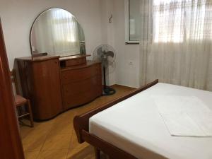 sypialnia z łóżkiem, komodą i lustrem w obiekcie Quality home w Sarandzie