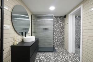 ein Bad mit einem Waschbecken und einem Spiegel in der Unterkunft Acacias Apartments - City Centre in Madrid