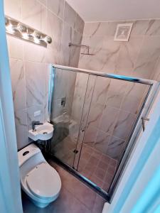 uma casa de banho com um chuveiro, um WC e um lavatório. em Punta Pacífica Oceanfront apartment na Cidade do Panamá