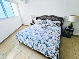 a bedroom with a bed with a blue and white comforter at Punta Pacífica Oceanfront apartment in Panama City