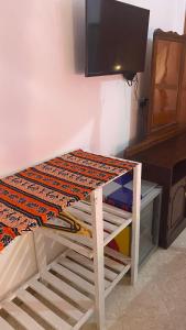 a wooden table with a tv on top of it at African Angel House B&B in Stone Town