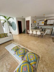 LA RESERVE VILLAS BEIJA-FLOR e IPANEMA في بيبا: غرفة معيشة مع أريكة وطاولة مع كراسي