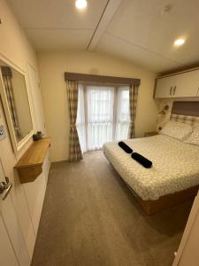 a small bedroom with a bed and a window at Sea view deluxe lodge in Lowestoft