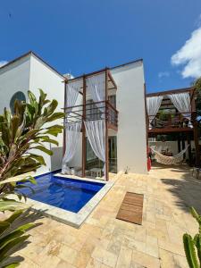 a villa with a swimming pool and a house at LA RESERVE VILLAS BEIJA-FLOR e IPANEMA in Pipa