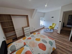 1 dormitorio con 1 cama y 1 habitación con silla en Gîte à 1,9 km du Mont St Michel en Beauvoir