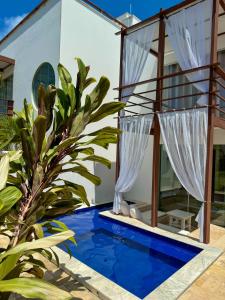 a villa with a pool and a house at LA RESERVE VILLAS BEIJA-FLOR e IPANEMA in Pipa