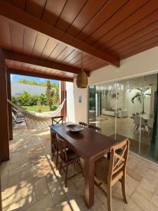 comedor con mesa de madera y sillas en LA RESERVE VILLAS BEIJA-FLOR e IPANEMA, en Pipa