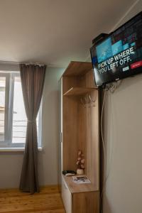 um quarto com uma televisão na parede e um frigorífico em Къща за гости Белоградчик em Belogradchik