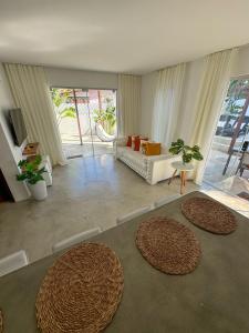 uma sala de estar com dois tapetes grandes no chão em LA RESERVE VILLAS BEIJA-FLOR e IPANEMA em Pipa