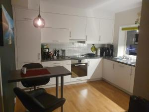 a kitchen with white cabinets and a table with chairs at Top Apartment in Tromsø