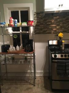 a kitchen with a stove and a shelf with dishes at Cozy urban aprtmt in San Antonio