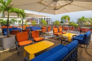 un patio con sillas coloridas, mesas y sombrillas en Four Points by Sheraton Lagos, en Lagos