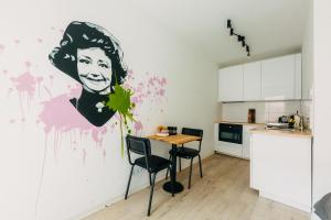 a kitchen with a painting of a woman on the wall at Düsseldorf Boutique-Style Studioapartments in Düsseldorf