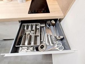 un cajón lleno de utensilios en la encimera de la cocina en Meublé Flora pour voyageur pro - Centre, calme - Wi-Fi en Haguenau