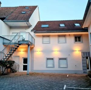 un edificio blanco con una escalera lateral en Meublé Flora pour voyageur pro - Centre, calme - Wi-Fi en Haguenau