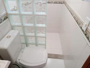 y baño con aseo blanco y ducha. en Apartamento cobertura em balneário Camboriú, en Balneário Camboriú