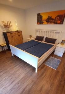 ein großes Bett in einem Schlafzimmer mit Holzboden in der Unterkunft Casa Rustica in Magadino